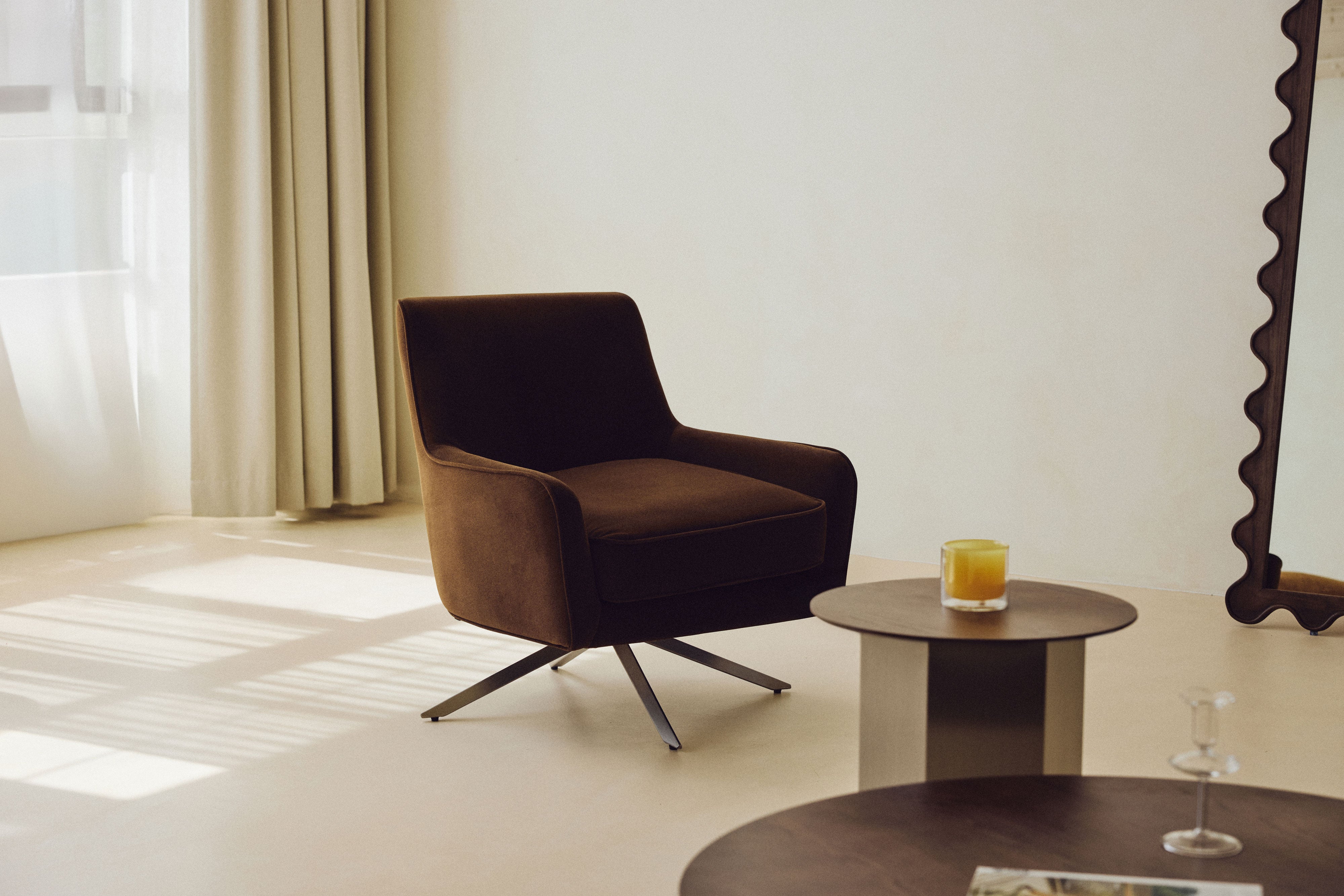 fauteuil Golden Gun - velours marron intense et piètement métal noir - vue paysage salon