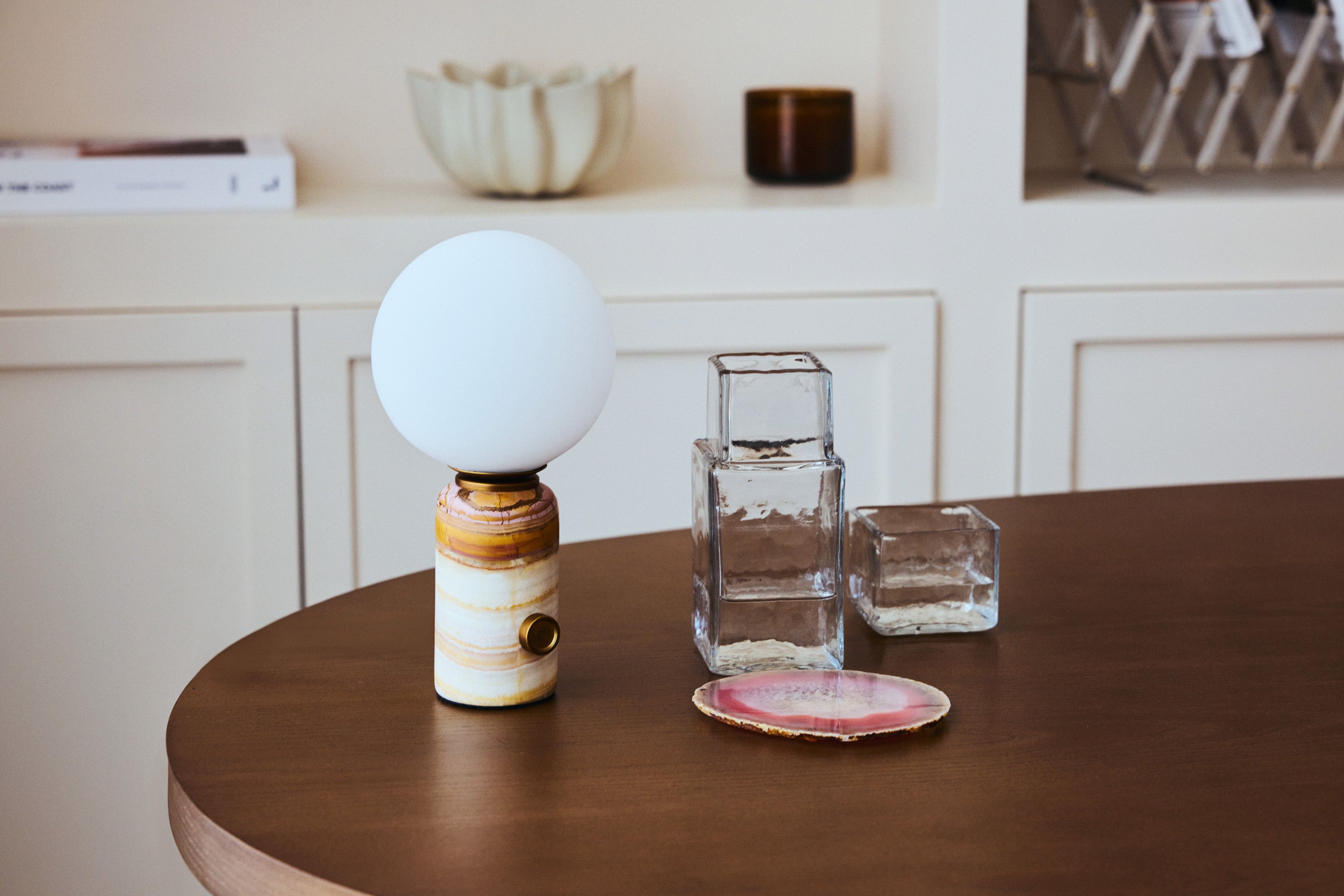 lampe Selene - marbre onyx rose et globe verre blanc - vue paysage table basse bois foncé