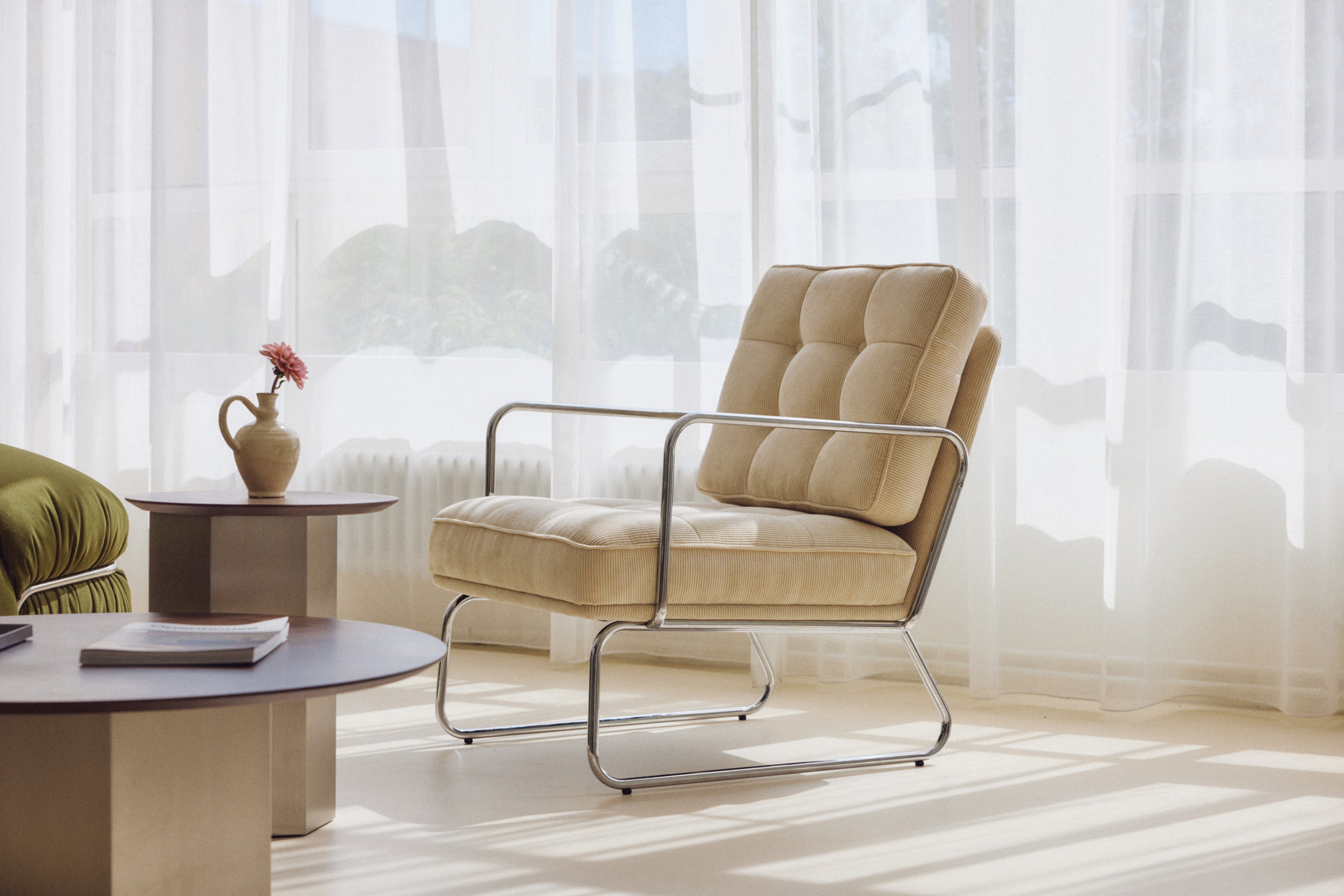 fauteuil Aurore - velours côtelé beige pampa et structure chromée - vue paysage avec table basse