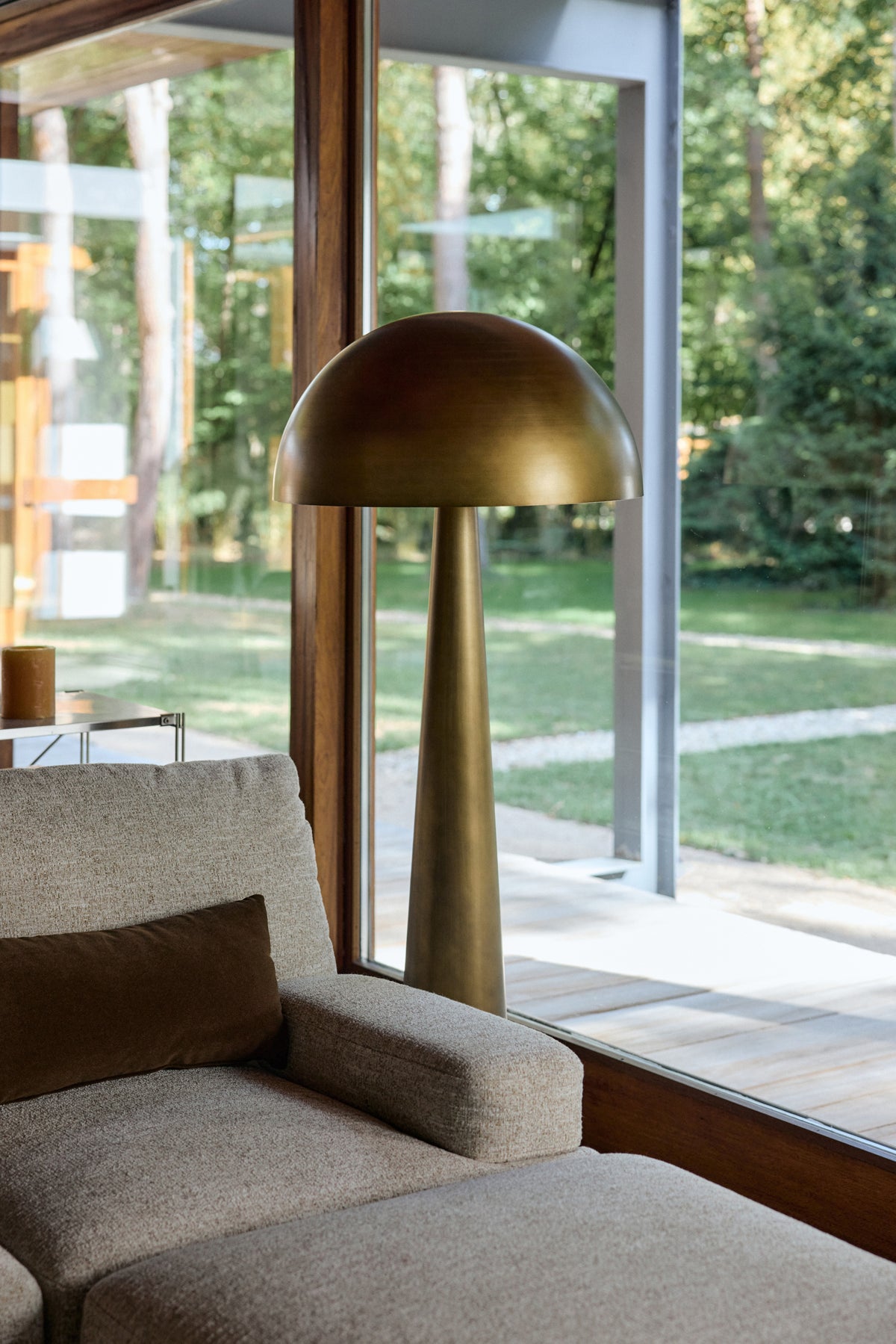 lampadaire Olympia en bronze près du canapé Roman écru et de la table basse Oron